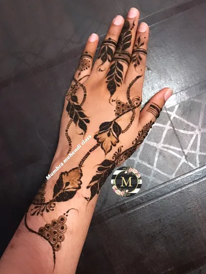 This is a Qatar-style design, featuring delicate chains and bold leaf motifs. It's a very graceful and modern look.