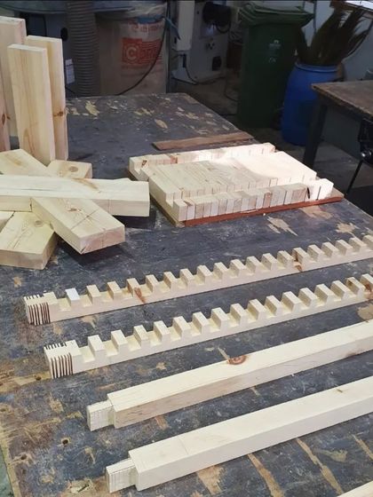 The disassembled components of a bench, showcasing the precise joinery, including mortise and tenon joints, cut by the students.