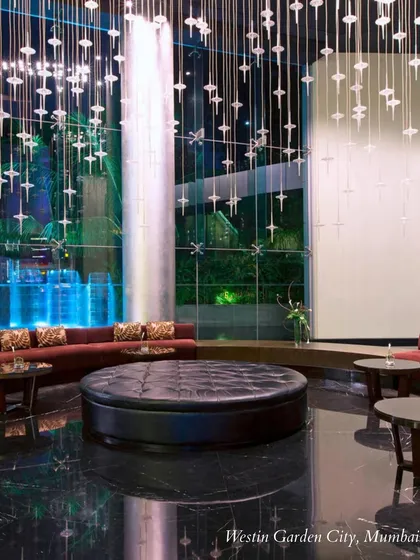 The dramatic, contemporary lobby of the Westin Garden City, Mumbai, with its signature waterfall. This venue is perfect for couples seeking a modern and sophisticated aesthetic.