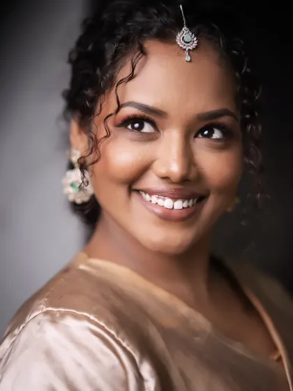 A smiling shot of a model with beautiful, natural makeup and curly hair.