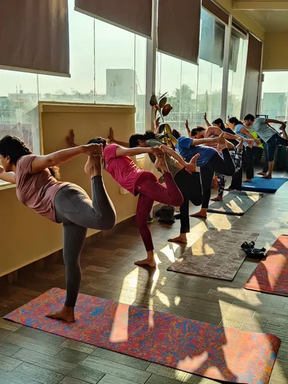 Students practicing Natarajasana (Dancer's Pose) in a line. It's beautiful to see the different expressions of the pose as each student finds their own balance and focus.