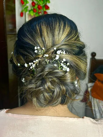 A soft and messy updo with delicate baby's breath woven through. This hairstyle is perfect for a romantic, bohemian-inspired look for any pre-wedding event.