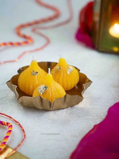 These yellow modak candles are a tribute to festive traditions. I make them from soy wax and add a touch of gold leaf for that extra sparkle.