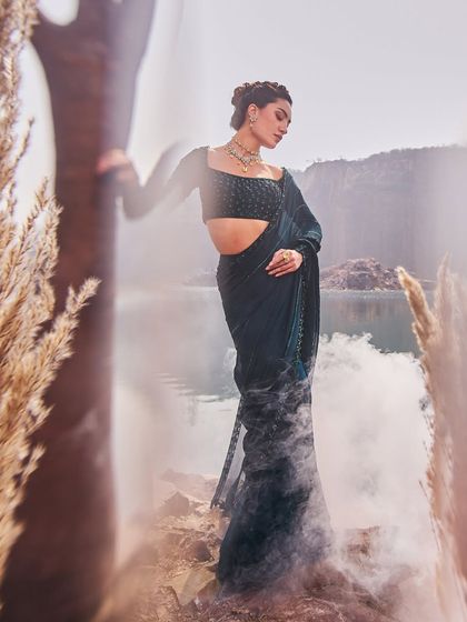 A model poses in a stunning jewel-toned ensemble by Nidhika Shekhar, a timeless nod to royal Indian heritage.