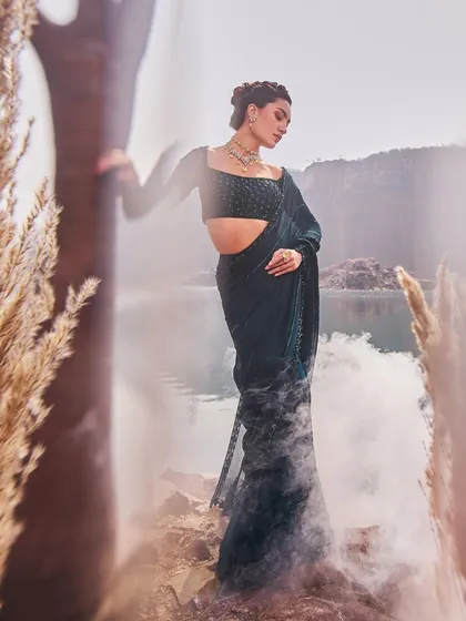 A model poses in a stunning jewel-toned ensemble by Nidhika Shekhar, a timeless nod to royal Indian heritage.