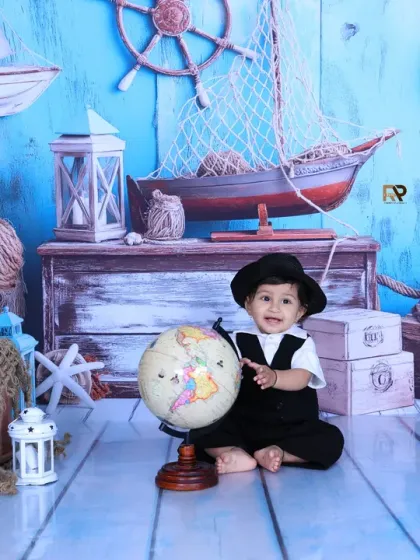A baby sailor points to a globe, ready to explore the world. This shot captures the curiosity and adventurous spirit of childhood.