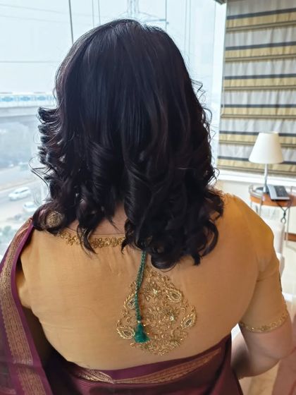 The back view of the short, curled hairstyle, showing the volume and shape that can be achieved even with shorter hair.