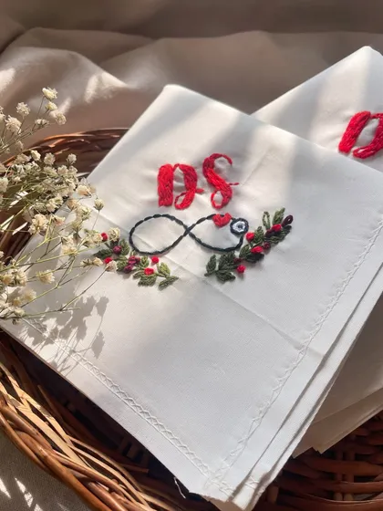 A detailed close-up of the embroidery on the handkerchief, showing the texture of the stitches.