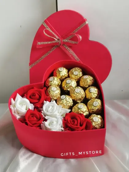 A top-down view of the heart-shaped box, showing the beautiful arrangement of chocolates and roses.