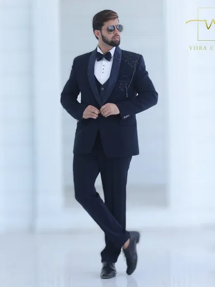 A full-length view of our bespoke navy blue tuxedo. The slim-fit tailoring ensures a modern silhouette, while the detailed handwork provides a touch of classic elegance.