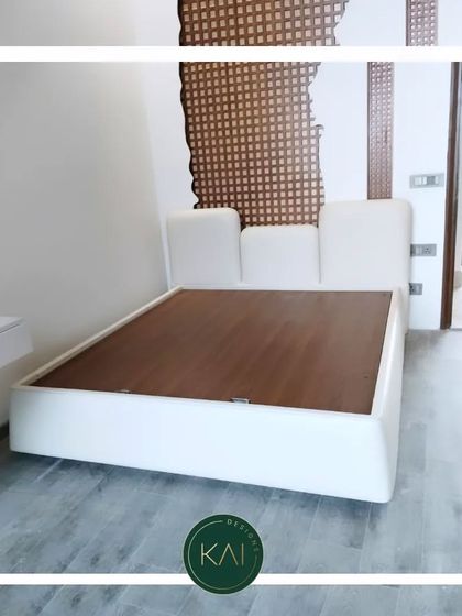 This modern platform bed features a low-profile, asymmetrical headboard in crisp white upholstery. Its minimalist design is perfect for creating a clean and uncluttered bedroom environment.