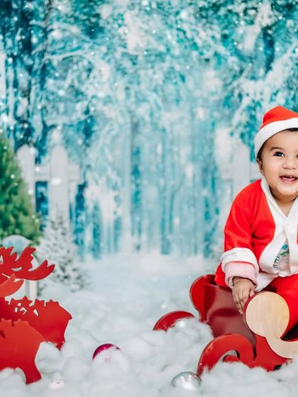 Dirt on his hands, chaos in his eyes. A happy baby Santa enjoys a sleigh ride in our winter wonderland studio setup.