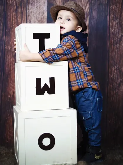 This two-year-old is having fun hugging the 'TWO' blocks during his birthday portrait session.