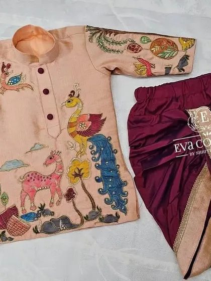 My designs for boys are just as special. This custom Kalamkari kurta features hand-painted nature motifs, paired with a comfortable and stylish maroon dhoti.