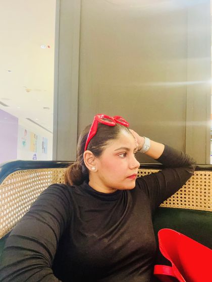 A candid moment of relaxation. Even in a simple black turtleneck, adding a fun accessory like these red heart-shaped glasses can show off your personality.