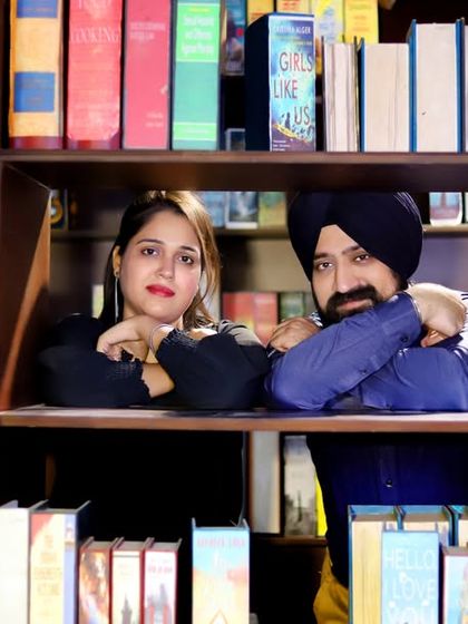 A creative and playful shot using a library set. The couple is framed within the bookshelves, creating a unique and personal portrait for book lovers.