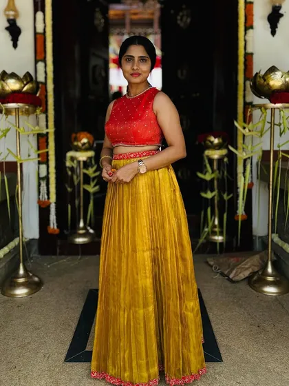 A full-length view of the client in the Kanchivaram tissue skirt and red crop top, a perfect blend of traditional material and modern style.