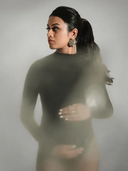 An artistic maternity portrait using a foreground blur effect to create a dreamy, ethereal mood.