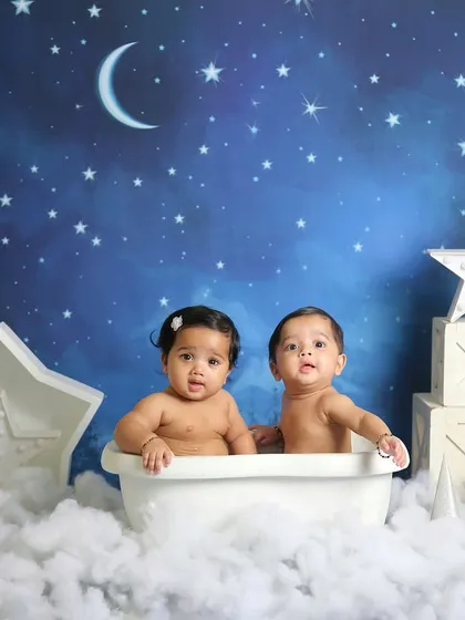 Twin babies enjoying a bubble bath in the stars. This creative setup is perfect for a magical and memorable twin photoshoot.