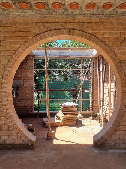 A circular archway being constructed with stabilized earth blocks at the 'FM-177' site. This feature frames the view and creates a beautiful play of light and shadow.