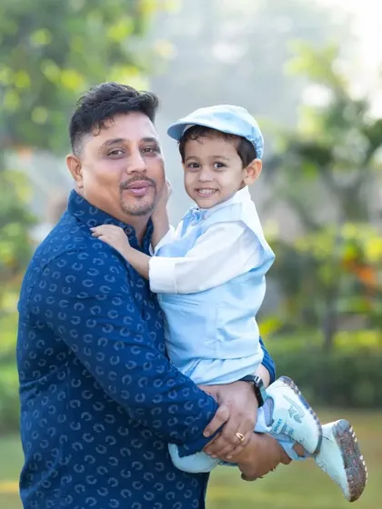A proud father holding his son during his third birthday photoshoot.