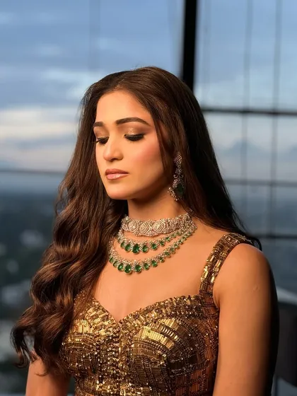 A close-up portrait showing the soft waves framing the client's face, paired with glamorous makeup.