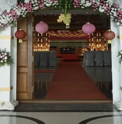 A view of the main hall entrance we decorated for a large event. The doorway is framed with floral arrangements, and hanging lanterns add a festive touch to welcome the guests inside.
