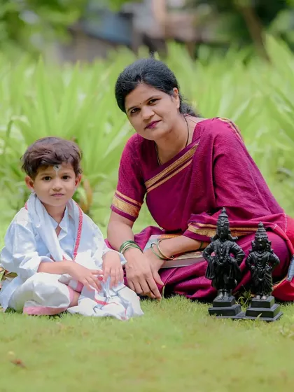 A beautiful portrait of mother and son during a Maharashtrian themed shoot. The presence of the Vithoba-Rukmini idols adds a layer of spiritual and cultural significance to this family photograph.