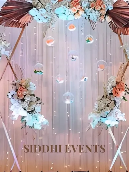 A modern hexagonal arch provides a geometric frame for this beautiful floral arrangement, featuring hanging glass orbs and a backdrop of fairy lights.