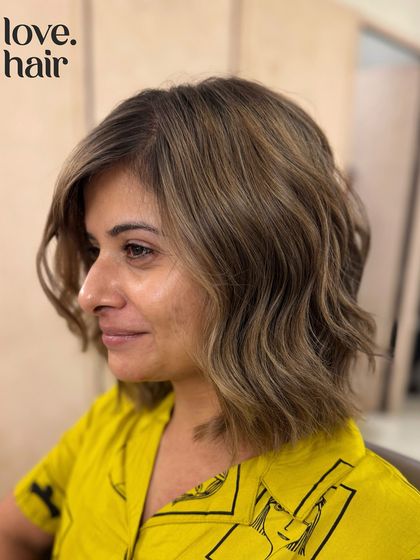 The happy client reveal of her ash blonde transformation. The cool tones are a perfect match for her stylish look.