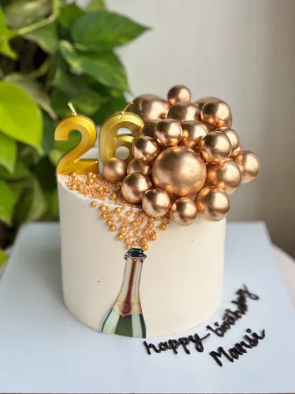 The full champagne-popping cake, complete with a personalized "Happy Birthday Mansi" message.