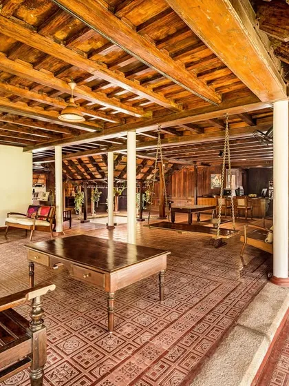 A wide view of the Aranmula Palace's reception area, showcasing the beautiful patterned floor and wooden pillars. This space is designed to create a sense of calm and wonder from the moment you arrive.