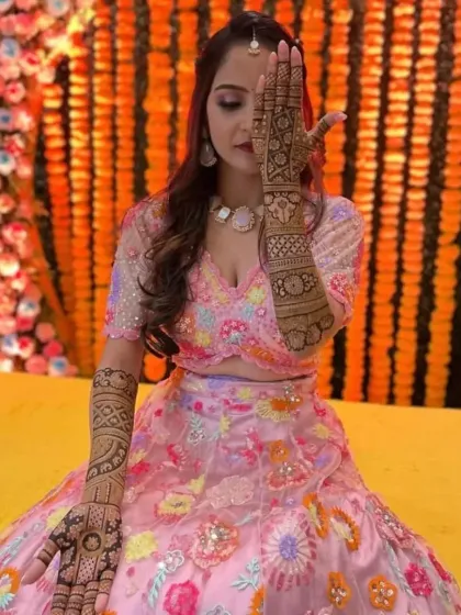 A classic bridal pose, with the intricate mehandi on one hand beautifully displayed.