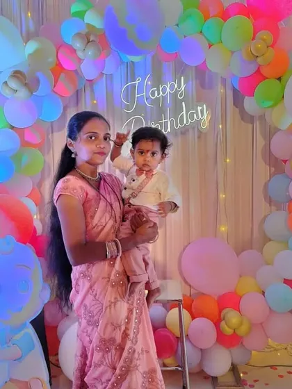 The mother and birthday boy posing against the vibrant, multi-colored balloon arch. We use high-quality balloons to create full and colorful arrangements that look great in photos.
