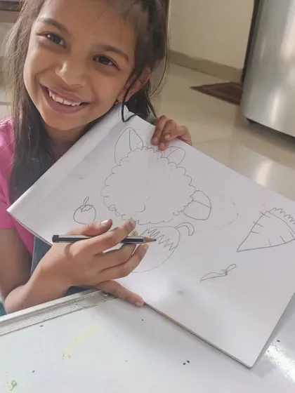 This is Eva, beaming with pride. When she joined, her attention span was a challenge, but through targeted art exercises, her focus and confidence have blossomed. Her journey is a testament to how art can foster holistic child development.