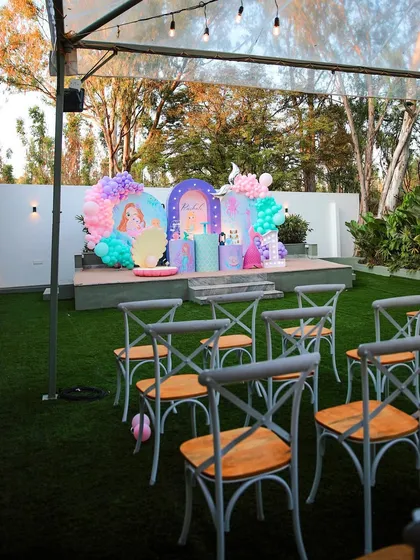 Another view of a kids' birthday party at The Backyard. The colorful stage decor and open lawn space are perfect for a fun and energetic celebration.