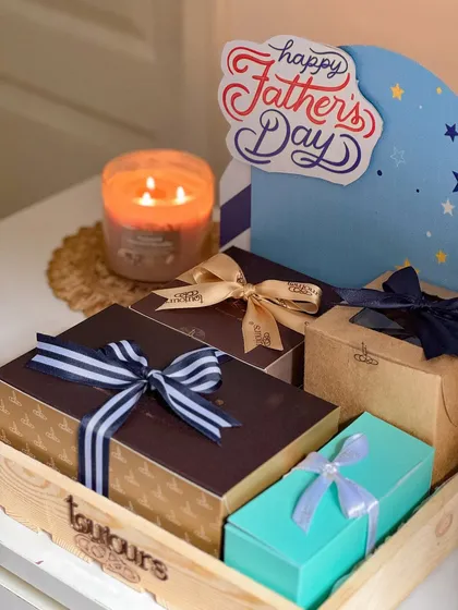 A Father's Day hamper in a wooden tray, filled with beautifully boxed treats and topped with a "Happy Father's Day" sign. This shows a larger, more comprehensive gifting option.