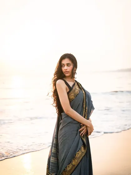 A three-quarter shot that showcases the drape of the saree and a gentle, elegant pose. The soft light is very flattering.