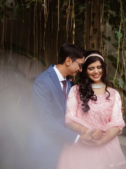 A tender moment between a couple during their engagement shoot. The soft focus on the foreground leaves creates a dreamy and intimate feel.