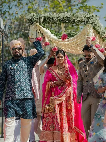 The bride's grand entrance in Udaipur, surrounded by her brothers and friends. The 'phoolon ki chadar' is not just a canopy; it's a circle of love and protection.