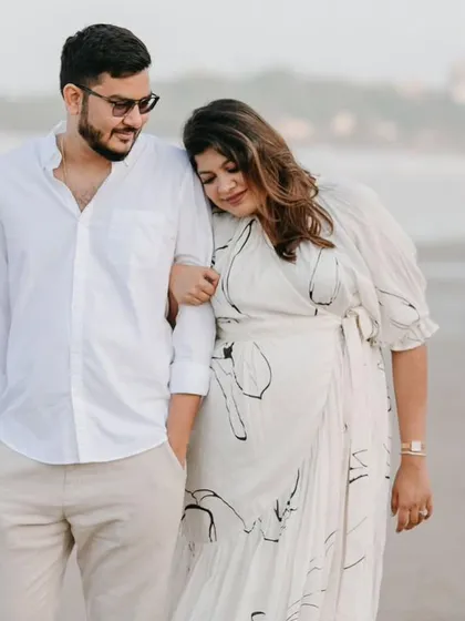 A tender moment between the parents-to-be. Her makeup is soft and natural, perfect for a relaxed and intimate photoshoot.