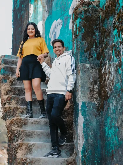 Another perspective of the couple posing on the steps of the rustic building in Mussoorie, showcasing their casual and comfortable style.