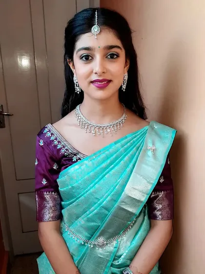 Here’s a fresh and youthful look I created for a house function. I used soft, shimmery eyeshadow and a pretty berry lip color to complement her bright turquoise saree, keeping the overall feel light and celebratory.