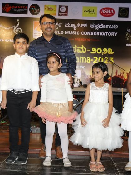 The full group of young keyboardists with their guru. Group performances help students learn to play in sync and build camaraderie.