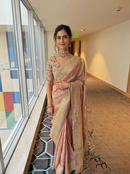 A full-length shot of the minimalist look, showing the elegant drape of the dusty rose saree.