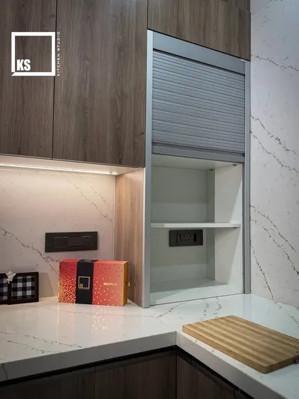 Here you can see the appliance garage with a metallic rolling shutter, keeping small appliances hidden but accessible. This is a key feature for maintaining a clutter-free countertop.