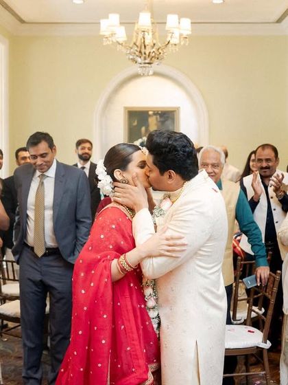 The first kiss after being pronounced married, surrounded by the applause of their loved ones. A peak emotional moment captured with warmth and intimacy.