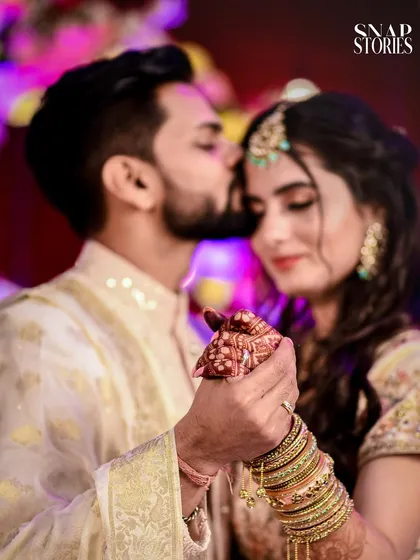 A tender moment on the dance floor, with the groom kissing the bride's forehead. We capture the romance and intimacy of your first dance and reception party.