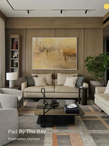 A look at the living room of 'Pad By The Bay' in Prabhadevi. The design uses a neutral palette and natural materials to create a calm, timeless feel, with a large abstract painting adding a splash of color and personality.