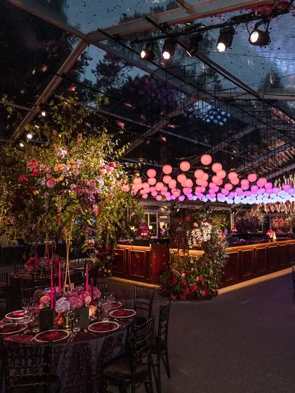 A moody, dramatic Sangeet inspired by the romance of Bridgerton. This setup in the British countryside features a clear-span marquee, lavish floral arrangements, and custom lighting to create a truly immersive, high-energy atmosphere.